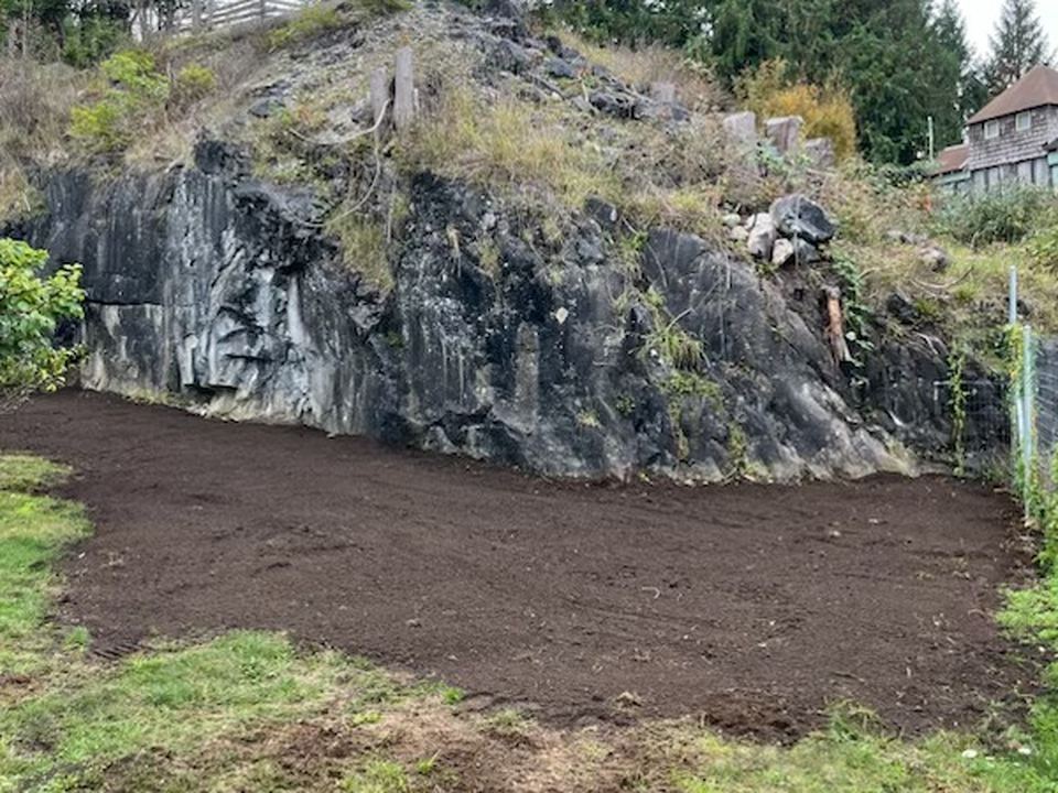 Ground cleared and levelled below a rock bank