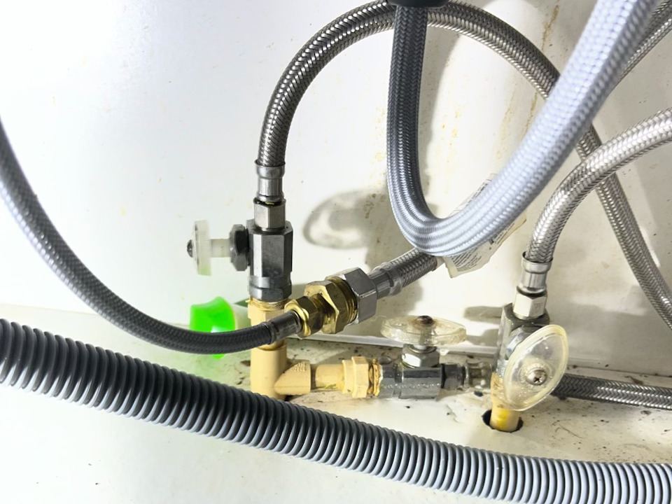 New shut-off valves and supply hoses behind a washing machine