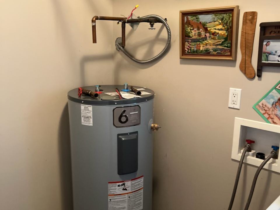 An electric hot water tank in a laundry room
